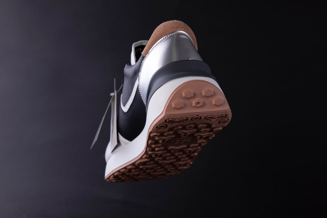 Dynamic low-angle shot of modern sneaker sole on black background.